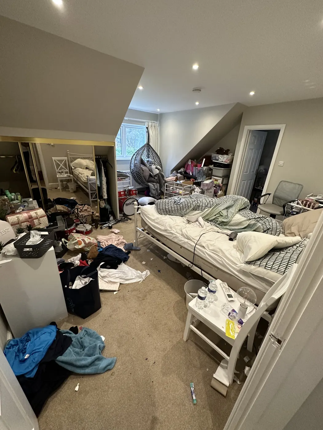 Teenager’s bedroom before: clothes and belongings covering the floor