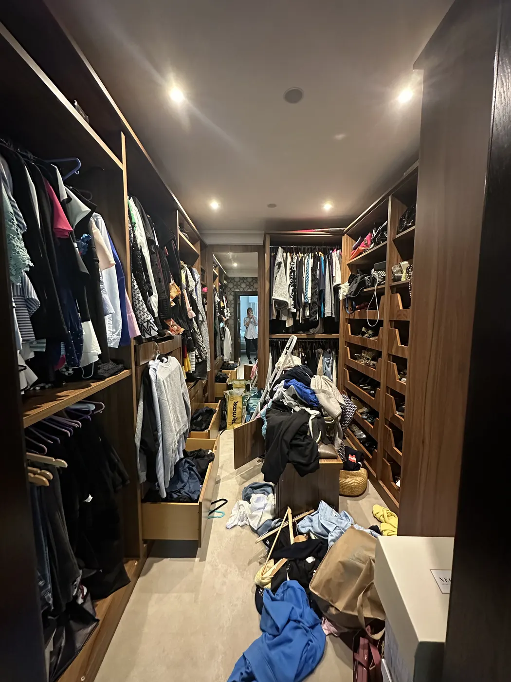 Walk-in dressing room before: clothes piled on the floor and shelves