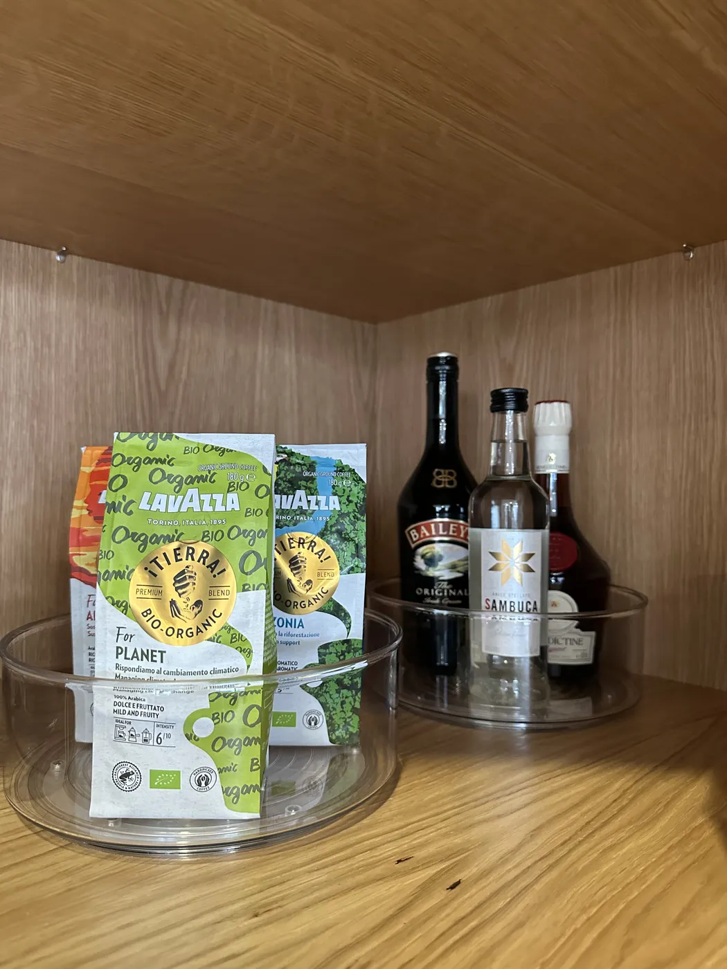 Coffee and spirits grouped on a clear turntable inside a cupboard