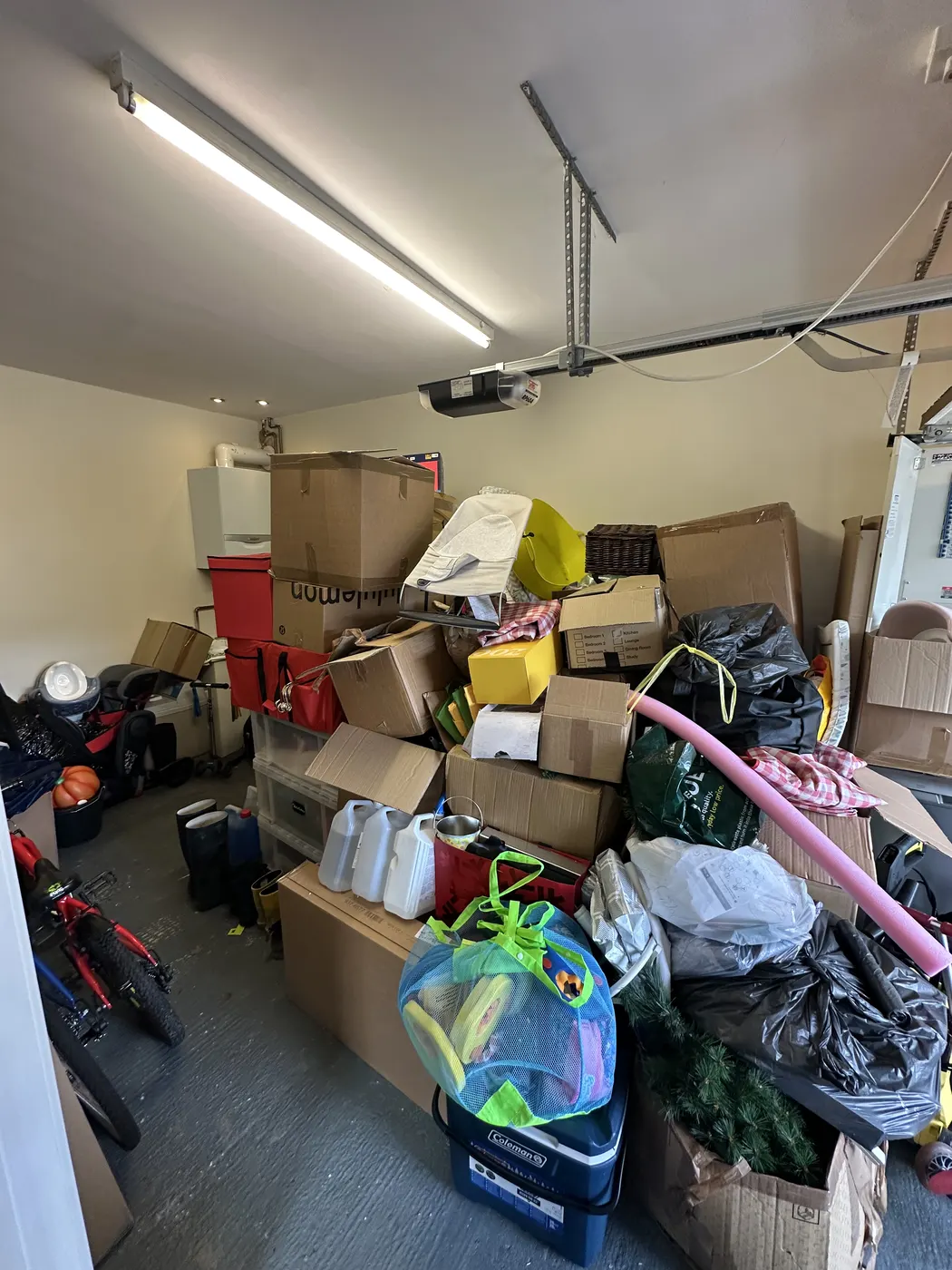 Garage before: boxes, bikes and bags piled across the floor