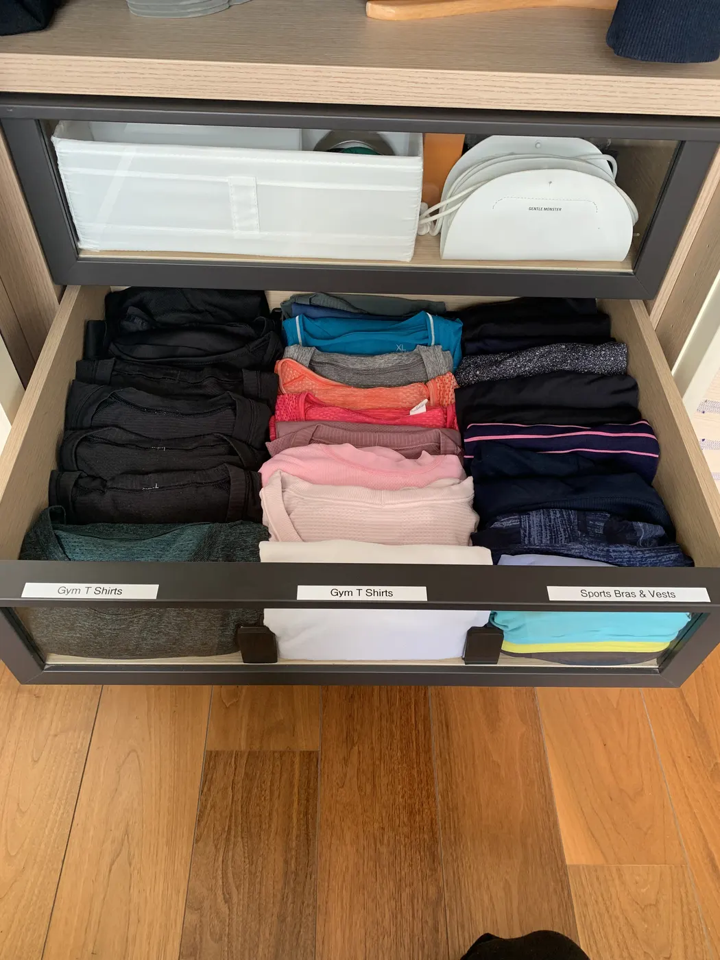Labelled wardrobe drawers holding neatly folded sportswear