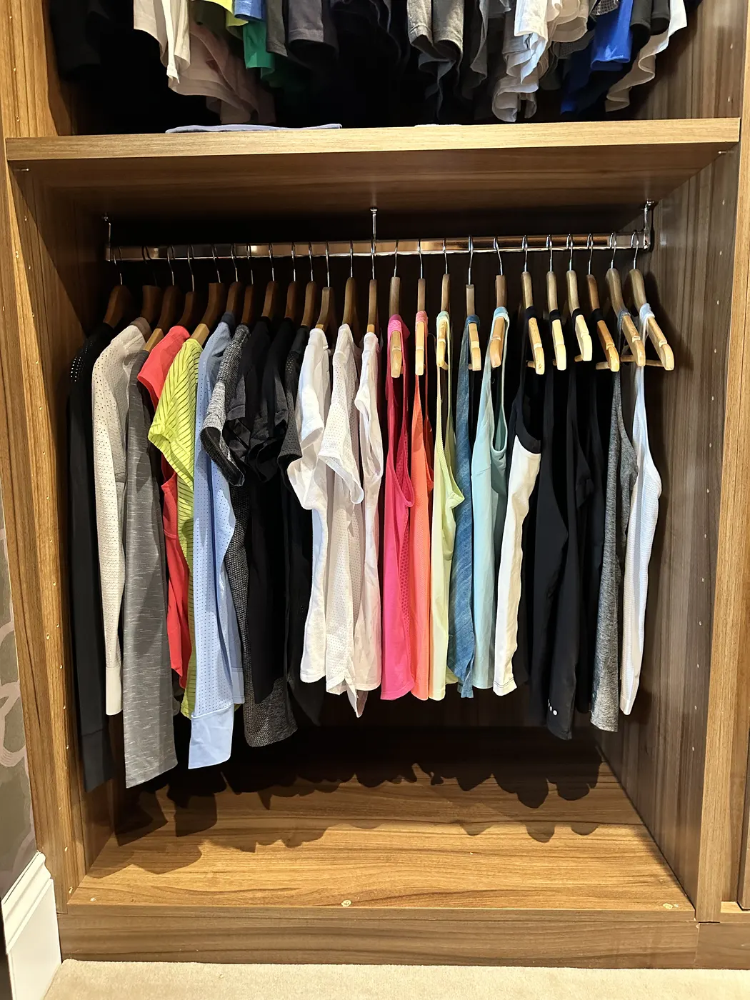 Hanging rail of shirts organised by colour