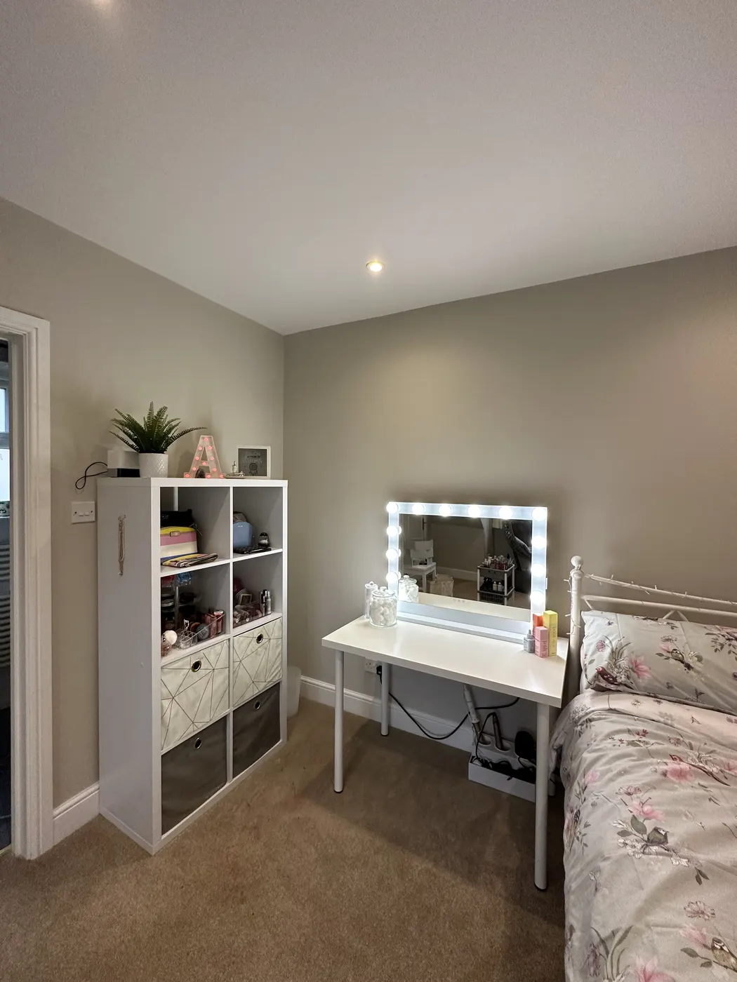The same bedroom after: clear floor, dressing table and white storage cubes